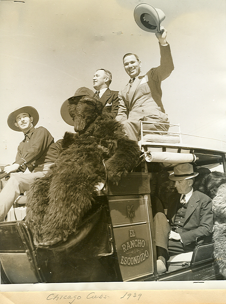 Dizzy Dean waving his hat as the Cubbies arrived for Spring Training in 1939; riding in the coach is E.R. Pollok